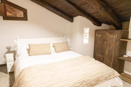 um quarto com uma cama branca e um tecto de madeira em Finca Eiras em Lugo