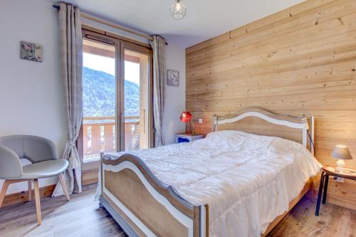une chambre avec un lit et une grande fenêtre dans l'établissement ALTAKA 3, à Morzine