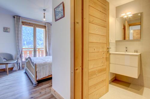 une chambre avec un lit, un lavabo et un miroir dans l'établissement ALTAKA 3, à Morzine