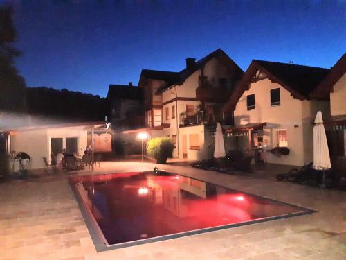a swimming pool in front of a house at night at Ferienanlage Beatrix in Stegersbach