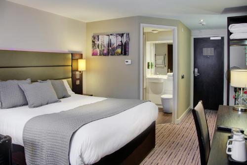a hotel room with a large bed and a bathroom at Fortune Huddersfield; Sure Hotel Collection by Best Western in Huddersfield