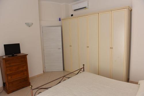 a bedroom with a bed and a dresser and a television at Villa Chiara in Salice Salentino