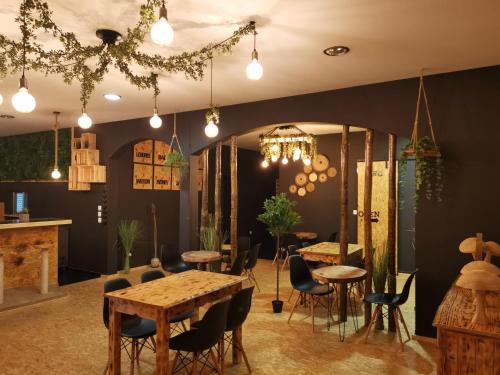 a dining room with tables and chairs and a chandelier at Atlantic Nature Beach House in Poço da Cruz