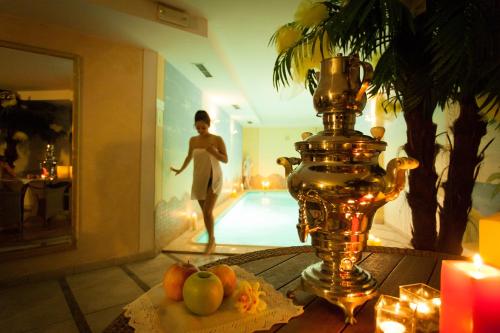 a table with a vase and a man walking by a pool at Sartori's Hotel in Trento