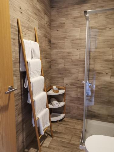 a bathroom with a towel rack next to a shower at Atlantic Nature Beach House in Poço da Cruz