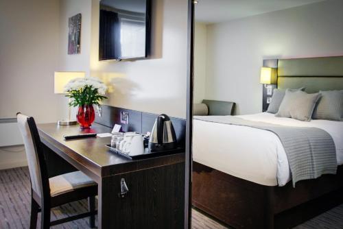una camera d'albergo con letto e scrivania con telefono di Fortune Huddersfield; Sure Hotel Collection by Best Western a Huddersfield