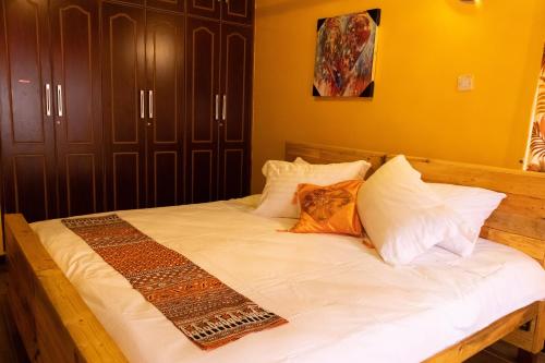 a bed with white sheets and pillows in a bedroom at Edaala Comfort - B&B in Nairobi