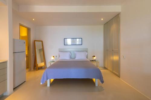 a bedroom with a bed with a blue bedspread at Kea Village Suites & Villas in Ioulida