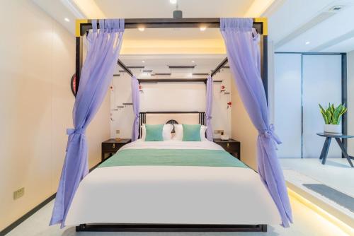 a bedroom with a bed with blue curtains at Cloudy international apartment Beijing Rd A-mall in Guangzhou