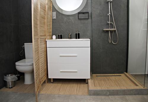 uma casa de banho com um lavatório branco e um WC. em Player's Pool&Rooms em Vonyarcvashegy