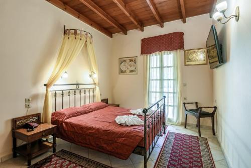 a bedroom with a red bed and a window at Belmondo Hotel in Chania Town