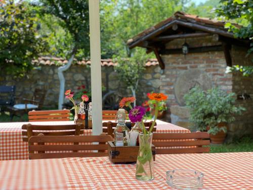 a table with flowers in vases on top of it at Konak Tosa in Poganovo
