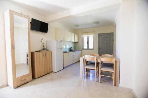 a kitchen with a table and a white refrigerator at Villa Blanca in Petrovac na Moru