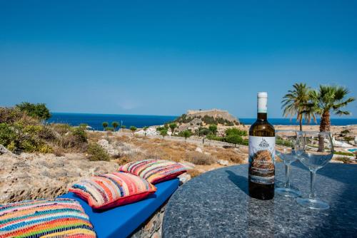 a bottle of wine sitting on a table with a glass at KRANA Hotel in Líndos