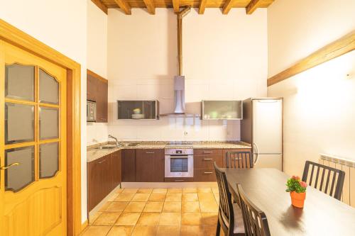 cocina con mesa y nevera en Casa rural Gibelea txiki en Viscarret-Guerendiáin