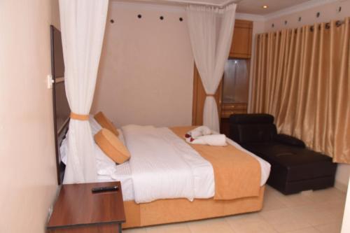 a bedroom with a bed and a chair and a mirror at Nairobi Glory Palace Hotel Ltd in Nairobi