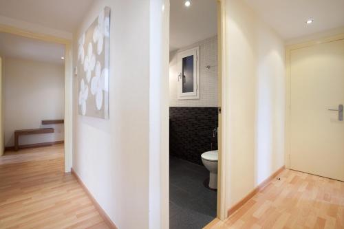 un couloir avec une salle de bains pourvue de toilettes. dans l'établissement RIUS - Modern apartment in the Montjuic, à Barcelone