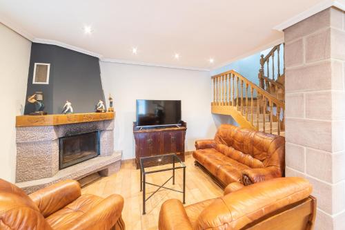 a living room with leather furniture and a fireplace at Casa rural Gibelea in Viscarret-Guerendiáin