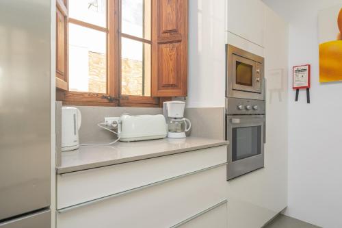 a kitchen with a counter with a sink and a microwave at Can Bombarda in Llubí