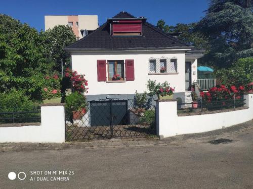 a white house with red shutters and a fence at Colmar "Room" chambre privée chez l'habitant,parking voiture devant la maison,garage moto et vélo,petit déjeuner in Colmar