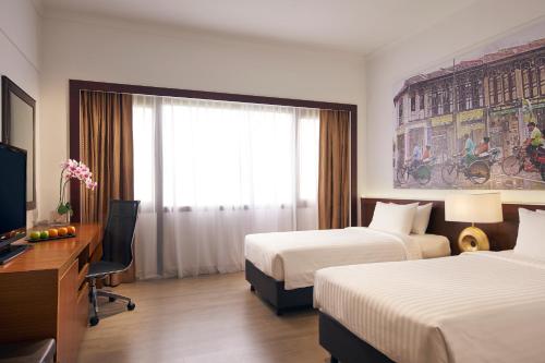 a hotel room with two beds and a television at Village Hotel Bugis by Far East Hospitality in Singapore
