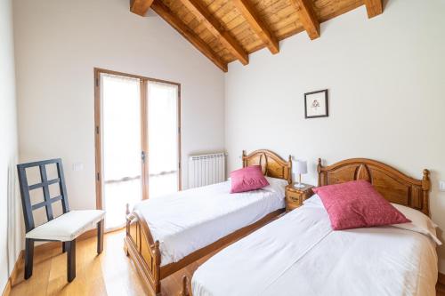 2 camas en una habitación con ventana en Casa rural Gibelea, en Viscarret-Guerendiáin