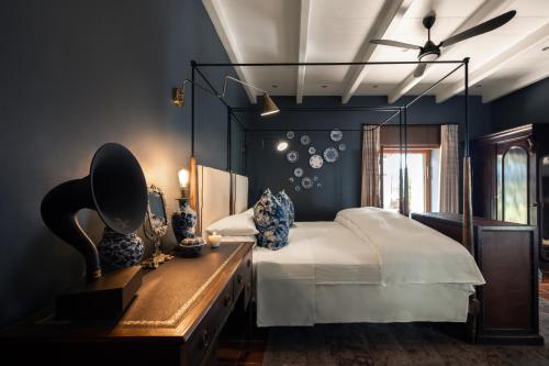 a bedroom with a bed and a dresser with a mirror at Akademie Street Boutique Hotel in Franschhoek