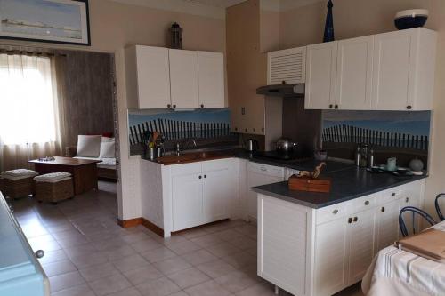 - une cuisine avec des placards blancs, un évier et une table dans l'établissement Maison indépendante et familiale en Camargue, à Salin-de-Giraud