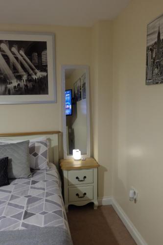 a bedroom with a bed and a dresser with a mirror at 15 Bronant in Talgarth