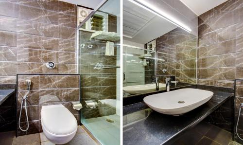 two pictures of a bathroom with a sink and a toilet at Treebo Primeland Suites in Bengaluru