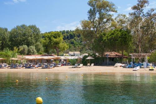 a group of chairs and umbrellas on a beach at Amouage Boutique Home in Skiathos Town