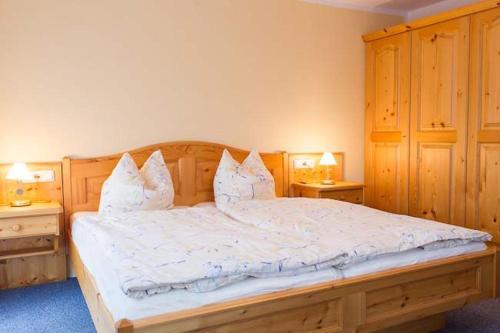 ein Schlafzimmer mit einem großen Bett mit weißer Bettwäsche und Kissen in der Unterkunft Ferienwohnung Brunnerlehen in Berchtesgaden