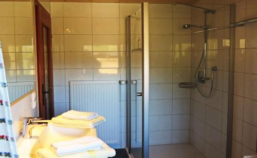 ein Badezimmer mit einer Dusche und drei gefalteten Handtüchern in der Unterkunft Ferienwohnung Brunnerlehen in Berchtesgaden