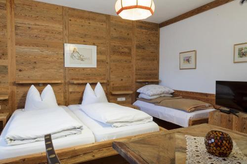 2 Betten in einem Zimmer mit Holzwänden in der Unterkunft Haus Kogler in Inzersdorf im Kremstal