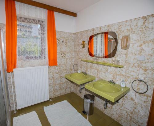 ein Badezimmer mit einem grünen Waschbecken und einem Spiegel in der Unterkunft Haus Kogler in Inzersdorf im Kremstal