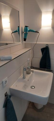 ein Bad mit einem Waschbecken und einem Spiegel in der Unterkunft Ferienhaus Richtermühle in Sebnitz