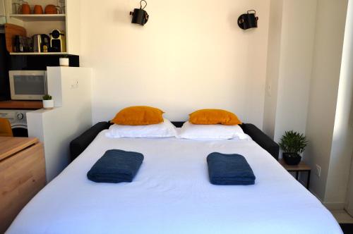 une chambre avec un lit avec deux oreillers dessus dans l'établissement Studio cosy - le châtelain, à Dieppe