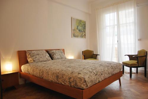ニースにあるLes Gérardines, 3-room with Airco and balconyのベッドルーム1室(ベッド1台、椅子2脚、窓付)