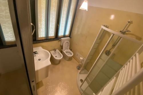 a bathroom with two toilets and a sink and a mirror at Macloud pub B&B in Sarnico