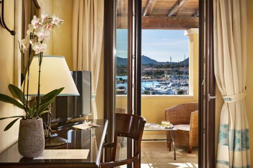 a hotel room with a desk and a window at La Vecchia Fonte Boutique Hotel in Palau