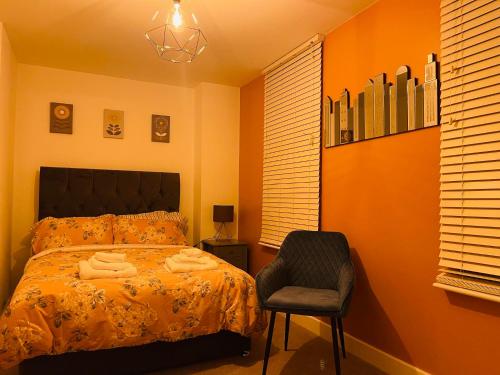 a bedroom with a bed and a chair at Cheerful 2-bed townhouse in Wakefield with parking in Wakefield