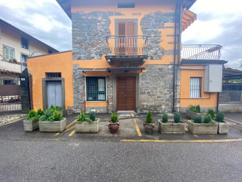a building with a bunch of potted plants in front of it at Macloud pub B&B in Sarnico