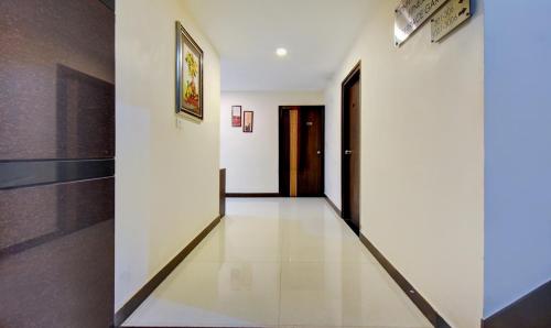 a hallway with white walls and black doors at Treebo Primeland Suites in Bengaluru
