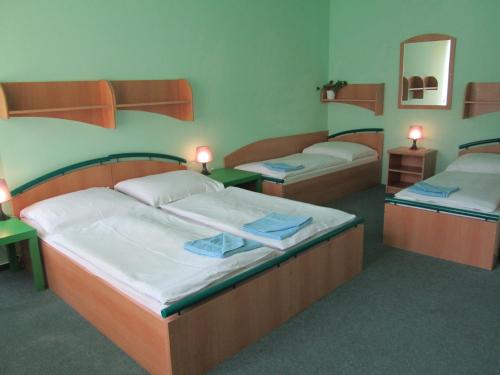 two beds in a room with two tables and two bunk beds at Hotel Union in Černý Dŭl