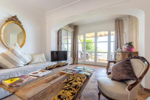 ein Wohnzimmer mit einem Sofa und einem Tisch in der Unterkunft Capri Suites de Charme by Napoliapartments in Anacapri