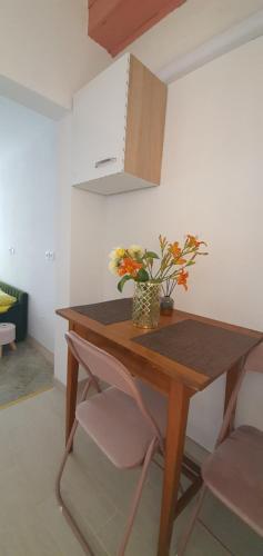 una mesa de madera con un jarrón de flores. en Apartma Jasna en Lokev