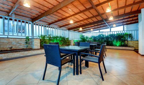 a dining room with a table and chairs on a patio at Treebo Primeland Suites in Bengaluru