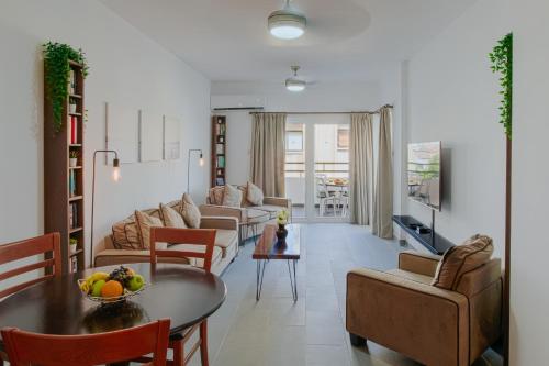 sala de estar con mesa, sillas y sofá en Lazaros Centre Apartment, en Lárnaca