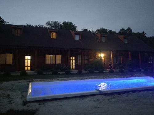 a swimming pool in front of a house at night at Karpatska Forel in Svalyava