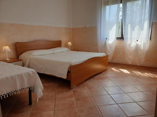a bedroom with a large bed and a window at Agriturismo Baratz in Santa Maria la Palma